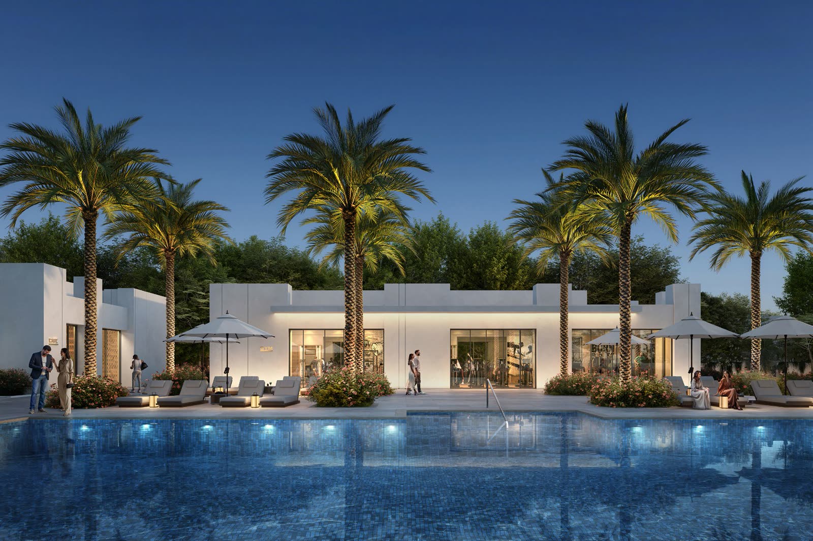 Clubhouse and landscaped pool deck lit at dusk, framed by palms