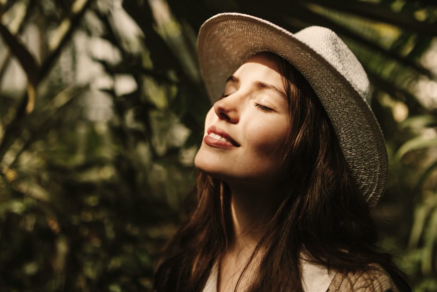 Woman resting in dappled light beneath the community's forest planting